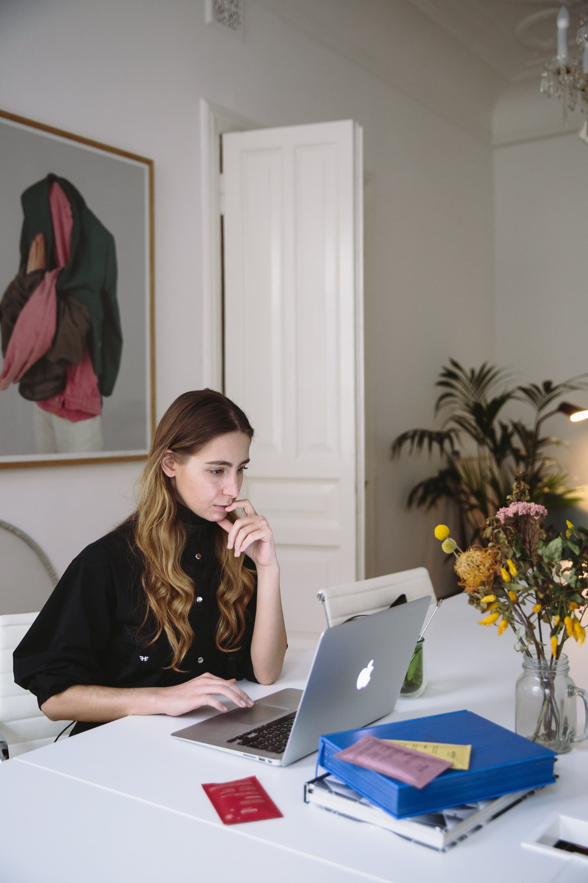 A woman working on a laptop at a dinning table